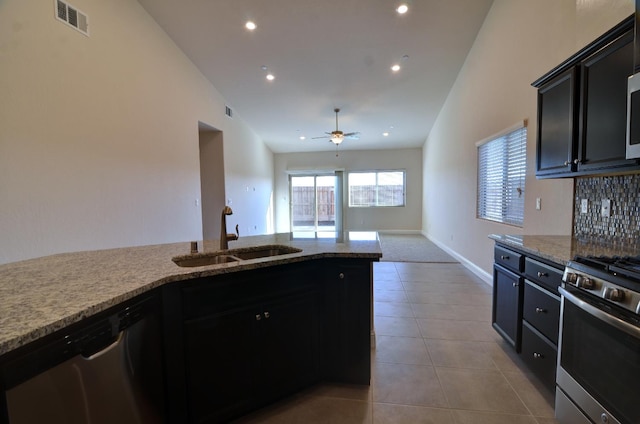 2129 La Canada Ave, Clovis, CA 93619 - kitchen with stainless steel appliances, a sink, ceiling fan, decorative backsplash, and light stone counters