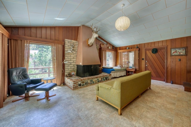 1140 Pine St, Fish Camp, CA 93623 - living room featuring plenty of natural light, wooden walls, lofted ceiling, and a fireplace