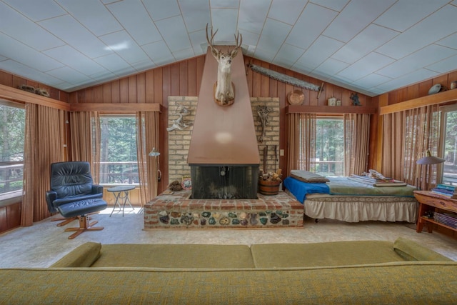 1140 Pine St, Fish Camp, CA 93623 - living area with lofted ceiling, healthy amount of natural light, wooden walls, a fireplace, and carpet flooring