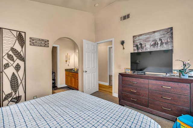 704 Rancho Vista Dr, Atwater, CA 95301 - carpeted bedroom with arched walkways, a towering ceiling, and baseboards