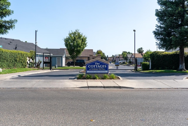 704 Rancho Vista Dr, Atwater, CA 95301 - view of asphalt street with a gate, curbs, street lights, and sidewalks
