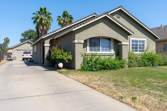 704 Rancho Vista Dr, Atwater, CA 95301 - view of front of house with stucco siding, a front yard, a detached garage, and an outbuilding