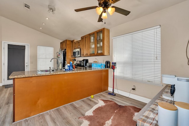 704 Rancho Vista Dr, Atwater, CA 95301 - kitchen with stainless steel appliances, brown cabinets, a peninsula, a ceiling fan, and lofted ceiling