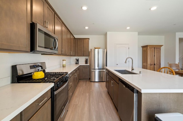 560 Overstone Ave, Madera, CA 93636 - kitchen with stainless steel appliances, a sink, a center island with sink, light wood-style flooring, and recessed lighting
