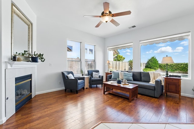 2721 Stuart Ave, Clovis, CA 93611 - living room with hardwood / wood-style flooring, a ceiling fan, a tile fireplace, and baseboards