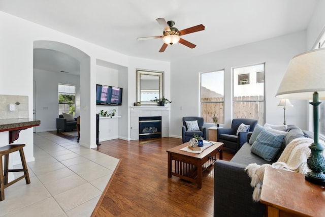 2721 Stuart Ave, Clovis, CA 93611 - living room featuring a ceiling fan, arched walkways, a fireplace, and light wood finished floors