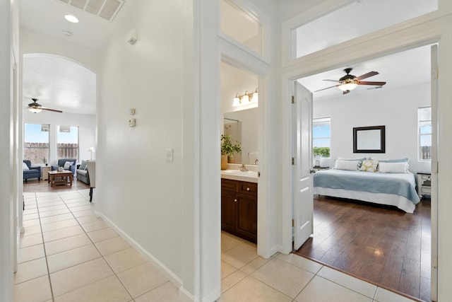 2721 Stuart Ave, Clovis, CA 93611 - corridor with light tile patterned floors, arched walkways, a sink, and baseboards