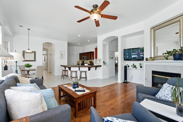 2721 Stuart Ave, Clovis, CA 93611 - living room featuring arched walkways, ceiling fan, a fireplace, light wood-style flooring, and recessed lighting