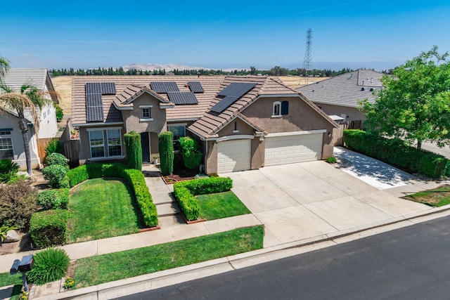 2721 Stuart Ave, Clovis, CA 93611 - traditional-style home featuring stucco siding, an attached garage, concrete driveway, roof mounted solar panels, and a tiled roof