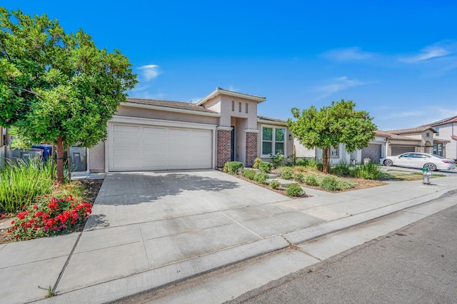 6085 E Homan Ave, Fresno, CA 93727 - view of front of house featuring a garage, stucco siding, driveway, and a tiled roof