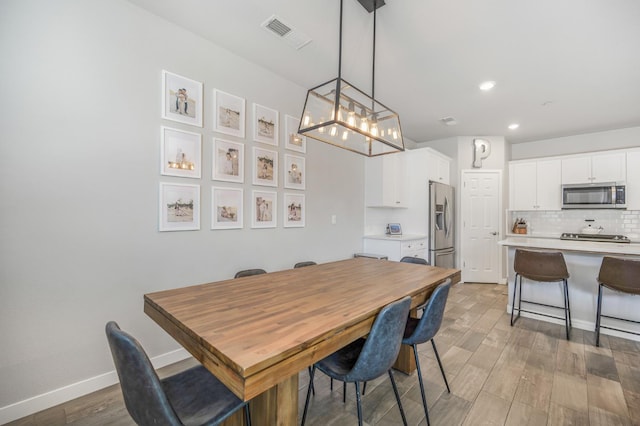 6085 E Homan Ave, Fresno, CA 93727 - dining area featuring light wood finished floors, baseboards, recessed lighting, and a chandelier