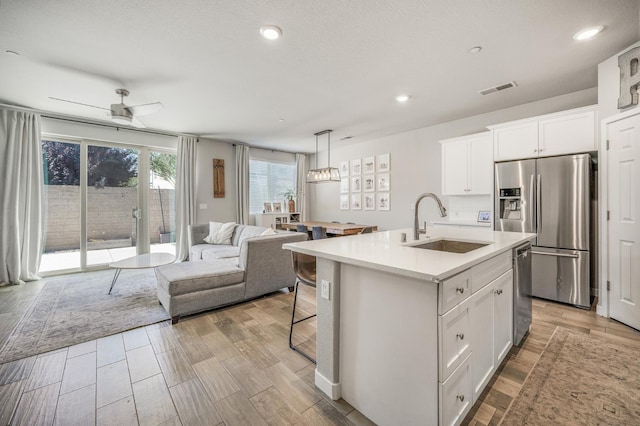 6085 E Homan Ave, Fresno, CA 93727 - kitchen with stainless steel appliances, a sink, open floor plan, light countertops, and white cabinetry
