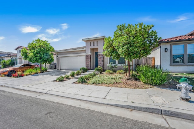 6085 E Homan Ave, Fresno, CA 93727 - view of front of house featuring a garage, stucco siding, concrete driveway, and a tiled roof