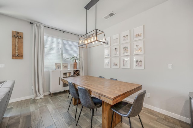 6085 E Homan Ave, Fresno, CA 93727 - dining area featuring a chandelier, wood finished floors, and baseboards