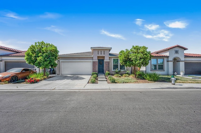 6085 E Homan Ave, Fresno, CA 93727 - view of front of house with an attached garage, driveway, a tiled roof, and stucco siding