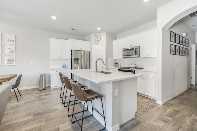 6085 E Homan Ave, Fresno, CA 93727 - kitchen featuring stainless steel appliances, a sink, a kitchen bar, decorative backsplash, and arched walkways