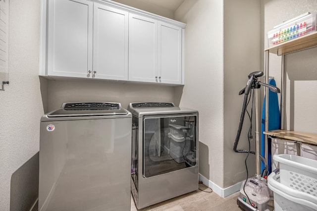 6085 E Homan Ave, Fresno, CA 93727 - laundry area with cabinet space, washer and dryer, light wood-style floors, and baseboards
