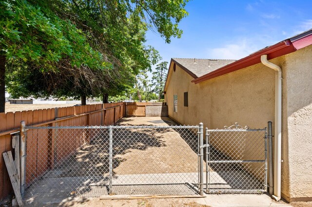 392 W Magill Ave, Clovis, CA 93612 - view of side of home with a gate, stucco siding, and a fenced backyard