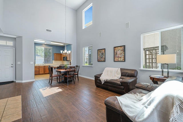 73 W Bordeaux Ln, Clovis, CA 93619 - living room featuring a chandelier, a towering ceiling, baseboards, and dark wood finished floors