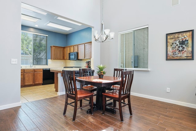 73 W Bordeaux Ln, Clovis, CA 93619 - dining area with a chandelier, light wood finished floors, baseboards, and a towering ceiling