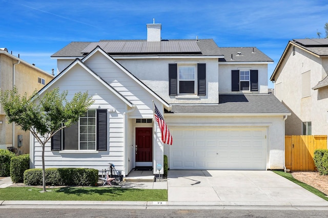 73 W Bordeaux Ln, Clovis, CA 93619 - traditional-style house featuring roof mounted solar panels, driveway, a chimney, and stucco siding
