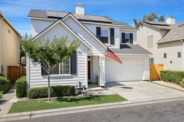 73 W Bordeaux Ln, Clovis, CA 93619 - traditional-style home featuring driveway, roof mounted solar panels, an attached garage, and a chimney