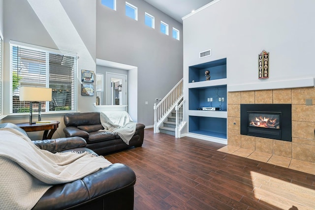 73 W Bordeaux Ln, Clovis, CA 93619 - living area with built in features, wood finished floors, baseboards, a towering ceiling, and a fireplace