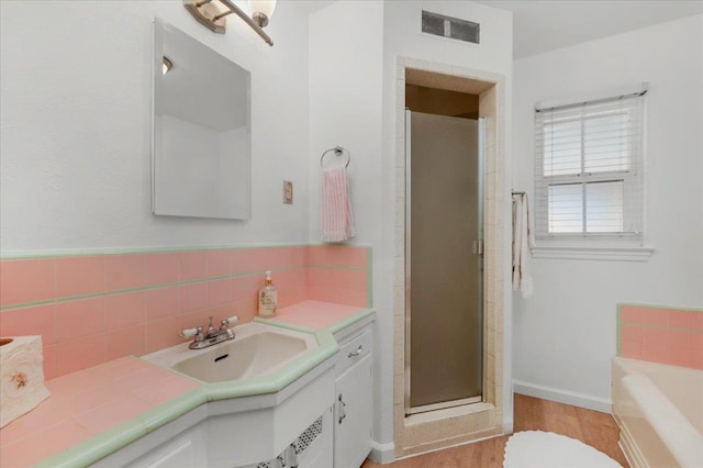 826 W Fedora Ave, Fresno, CA 93705 - full bathroom with vanity, a shower stall, wood finished floors, a bath, and baseboards