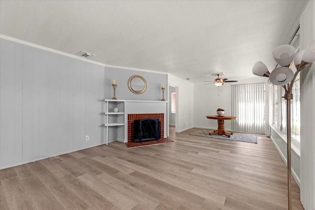 826 W Fedora Ave, Fresno, CA 93705 - unfurnished living room featuring light wood-style flooring, a textured ceiling, a ceiling fan, baseboards, and a brick fireplace