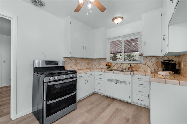 826 W Fedora Ave, Fresno, CA 93705 - kitchen featuring range with two ovens, a sink, light wood-style flooring, and tile countertops