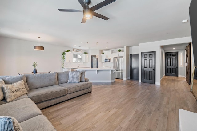 7374 E Flint Way, Fresno, CA 93737 - living room with a ceiling fan, light wood-type flooring, and baseboards