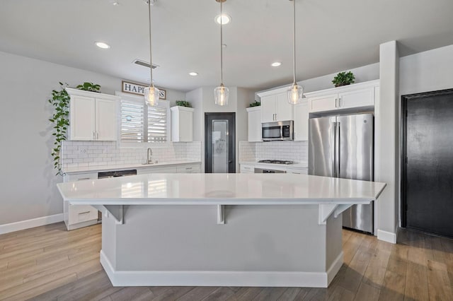 7374 E Flint Way, Fresno, CA 93737 - kitchen featuring stainless steel appliances, a sink, light countertops, white cabinetry, and a center island