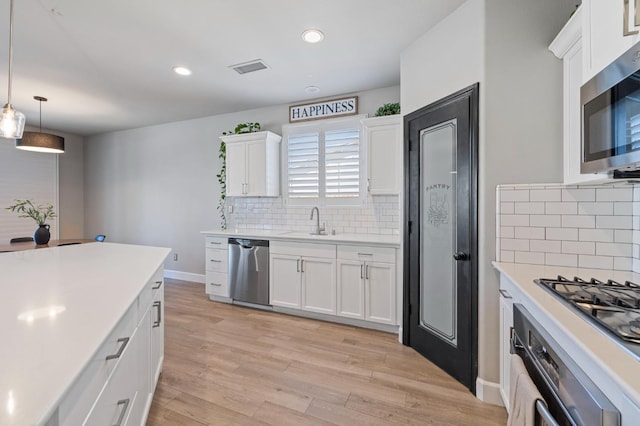 7374 E Flint Way, Fresno, CA 93737 - kitchen featuring appliances with stainless steel finishes, a sink, tasteful backsplash, light countertops, and recessed lighting