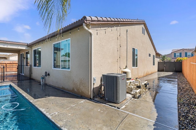 7374 E Flint Way, Fresno, CA 93737 - back of property with a fenced backyard, stucco siding, central air condition unit, and a patio
