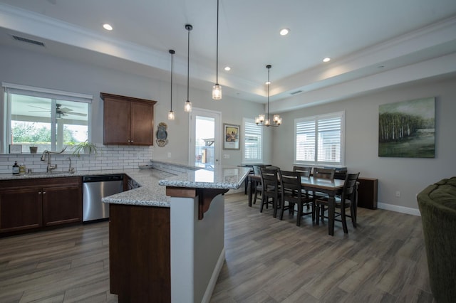 511 Timberline Way S, Madera, CA 93636 - kitchen featuring stainless steel dishwasher, a sink, a peninsula, a chandelier, and decorative backsplash