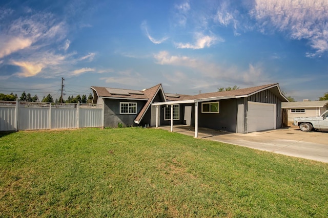 168 E Stuart Ave, Fresno, CA 93710 - rear view of property featuring an attached garage, solar panels, driveway, and stucco siding