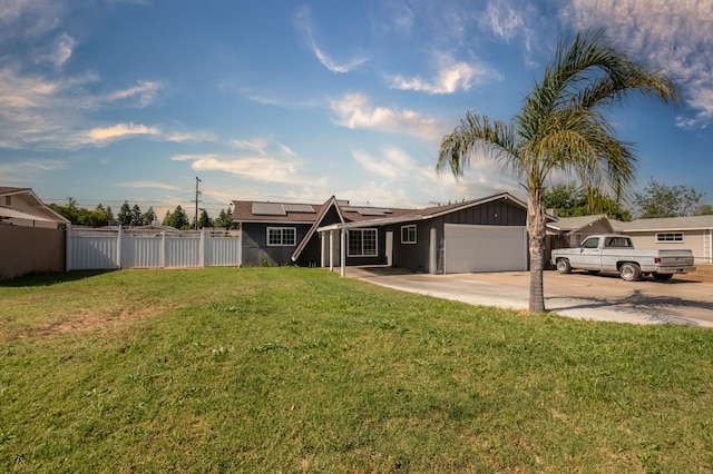 168 E Stuart Ave, Fresno, CA 93710 - view of front of house featuring an attached garage, roof mounted solar panels, and concrete driveway