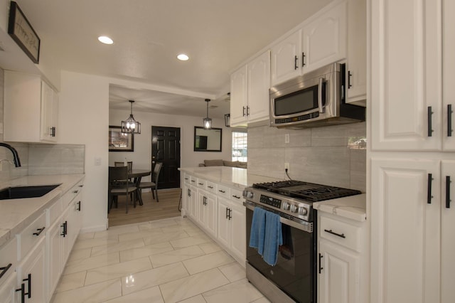 168 E Stuart Ave, Fresno, CA 93710 - kitchen with stainless steel appliances, a sink, tasteful backsplash, recessed lighting, and light stone countertops