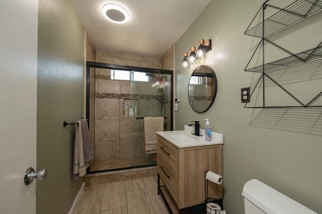 168 E Stuart Ave, Fresno, CA 93710 - bathroom with toilet, vanity, a shower stall, and baseboards