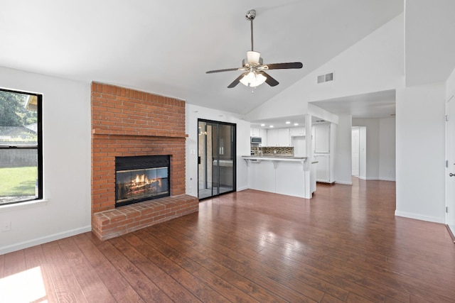 6546 N Bendel Ave, Fresno, CA 93722 - unfurnished living room featuring a ceiling fan, dark wood-style flooring, a brick fireplace, baseboards, and high vaulted ceiling