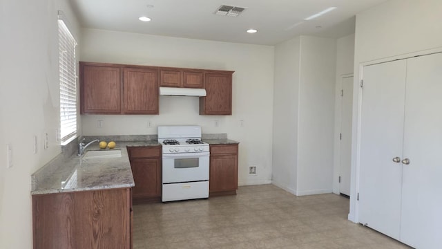 758 Persimmon, Madera, CA 93638 - kitchen featuring gas range gas stove, a sink, under cabinet range hood, light stone countertops, and light floors