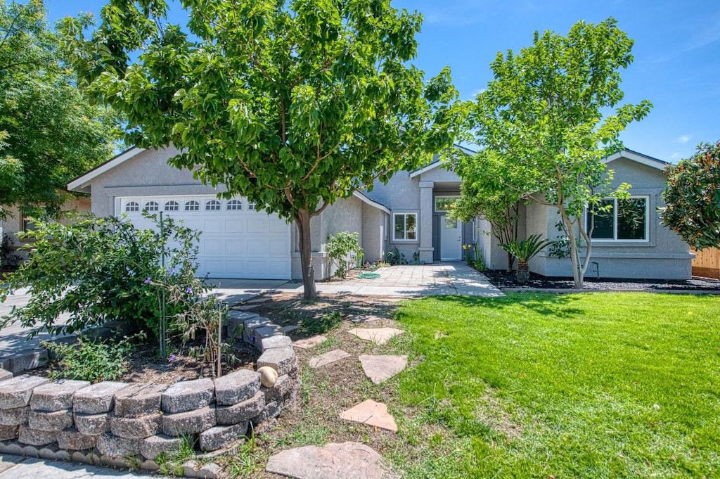 6357 E Mono St, Fresno, CA 93727 - obstructed view of property featuring an attached garage, a front yard, and stucco siding