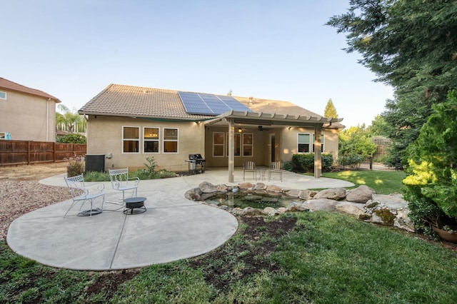 3126 San Gabriel Ave, Clovis, CA 93619 - back of house with a ceiling fan, a tile roof, solar panels, stucco siding, and a patio