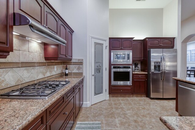 3126 San Gabriel Ave, Clovis, CA 93619 - kitchen with stainless steel appliances, under cabinet range hood, backsplash, and a high ceiling