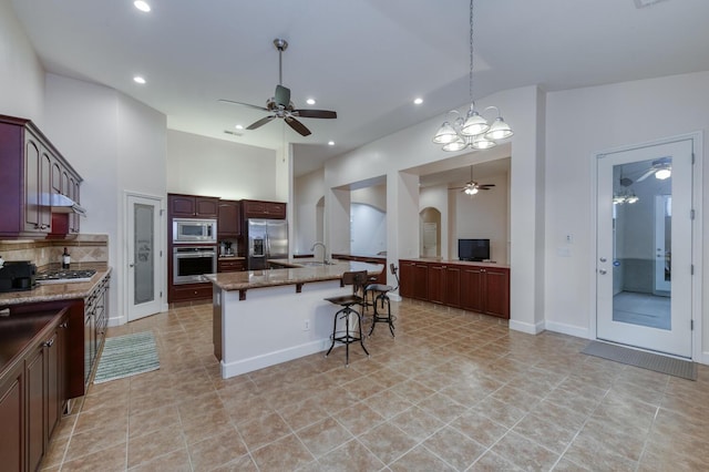 3126 San Gabriel Ave, Clovis, CA 93619 - kitchen featuring stainless steel appliances, ceiling fan, a breakfast bar, arched walkways, and a sink