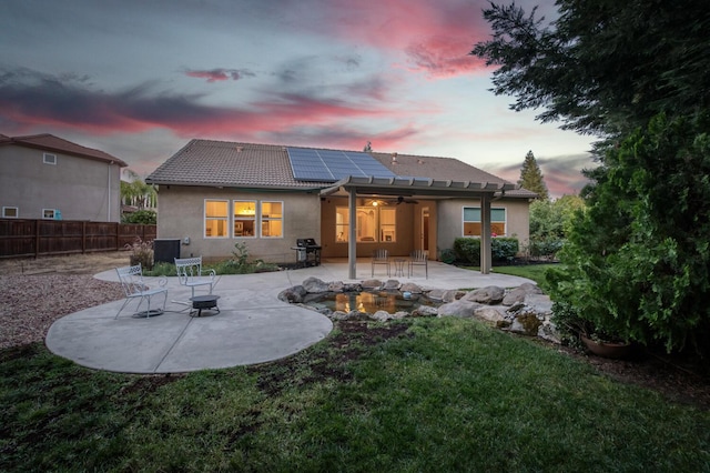 3126 San Gabriel Ave, Clovis, CA 93619 - back of house featuring a patio, ceiling fan, solar panels, stucco siding, and a tile roof