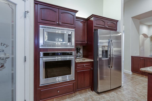 3126 San Gabriel Ave, Clovis, CA 93619 - kitchen with appliances with stainless steel finishes, dark brown cabinets, light stone counters, and light tile patterned flooring