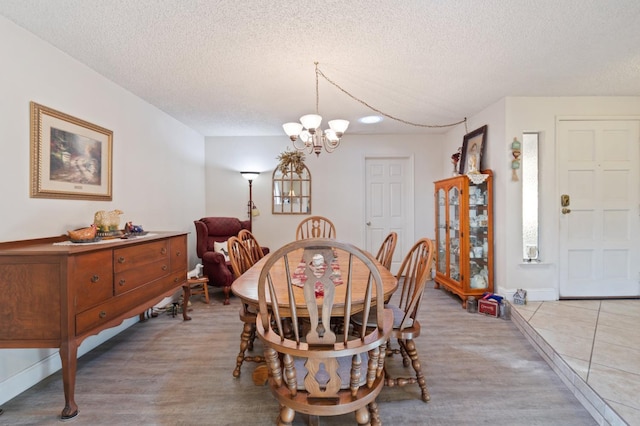 2724 Monocott Dr, Madera, CA 93637 - dining space with a textured ceiling, a chandelier, light wood finished floors, and baseboards