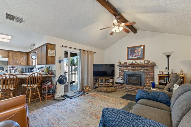 2724 Monocott Dr, Madera, CA 93637 - living area with wood finished floors, ceiling fan, a textured ceiling, and a brick fireplace