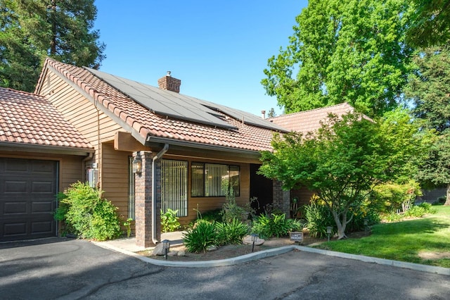 2063 W Barstow Ave, Fresno, CA 93711 - view of front of property featuring a tile roof, solar panels, and a chimney